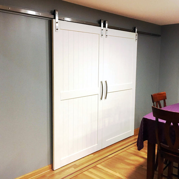 Sleekly modern Divided doors in white, with stainless steel Straight Strap soft close barn door hardware.