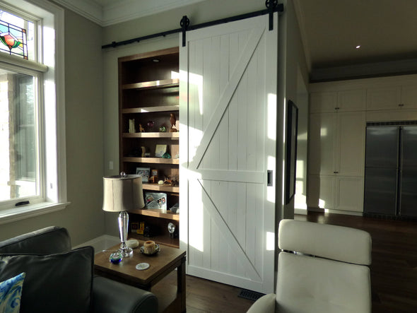 Creamy "K" style doors with soft close Big Wheel hardware, covering a closet
